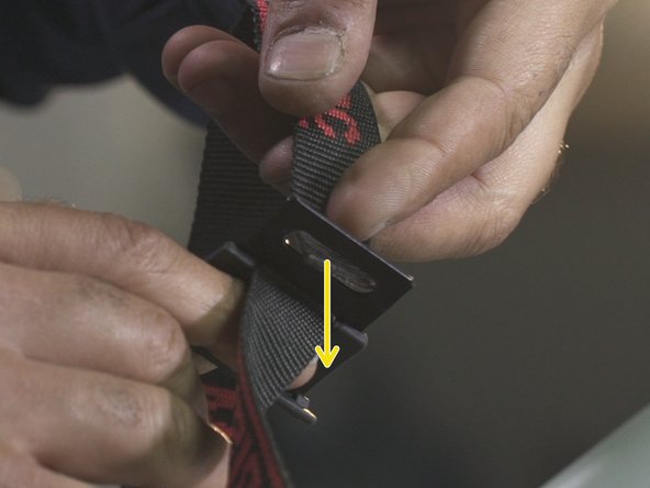 Rentre la sangle dans le premier trou de la boucle puis la faire ressortir par le second trou