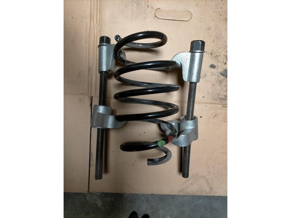 Déposer l'écrou de tige d'amortisseur avec une clé à oeil de 18 et une clé 6 pans. Moi j'utilise une clé à choc avec une douille de 18, c'est plus simple.