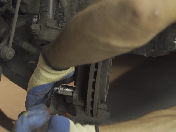 A l'aide du cliquet et d'une douille de 18 desserrer les deux vis de la chape d'étrier