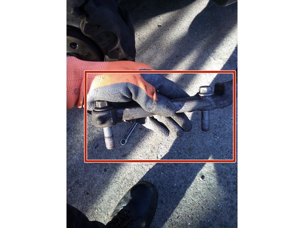 Dévissez les deux vis de la patte de fixation inférieure derrière l'étrier à l'aide d'une clé de 15.