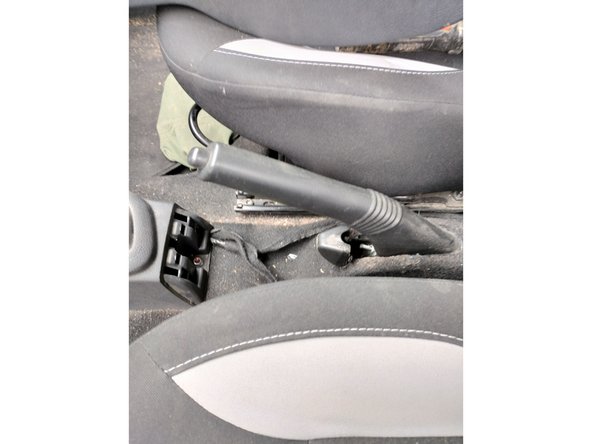 Reposer la console centrale et l'accoudoir à l'aide d'une clé Torx de 20, sans oublier de reconnecter les boutons de vitre arrière et de start and stop