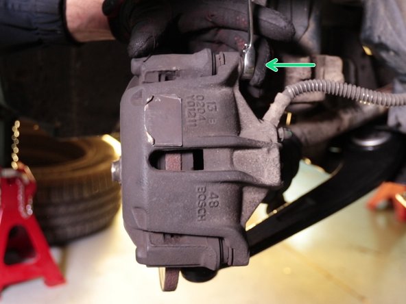 Dévisser et retirer la vis du haut de l'étrier toujours à l'aide d'une clé de 13