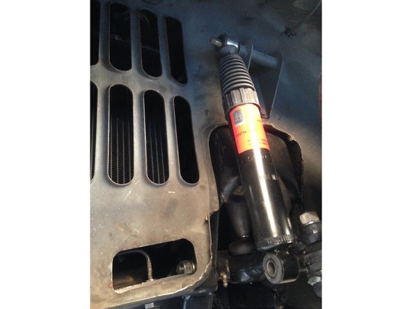 Remonter l'amortisseur. Pour la fixation du bas dans l'ordre il y a la vis / le bras de suspension / une entretoise (grosse rondelle) / une rondelle / l'amortisseur / une rondelle / l'écrou