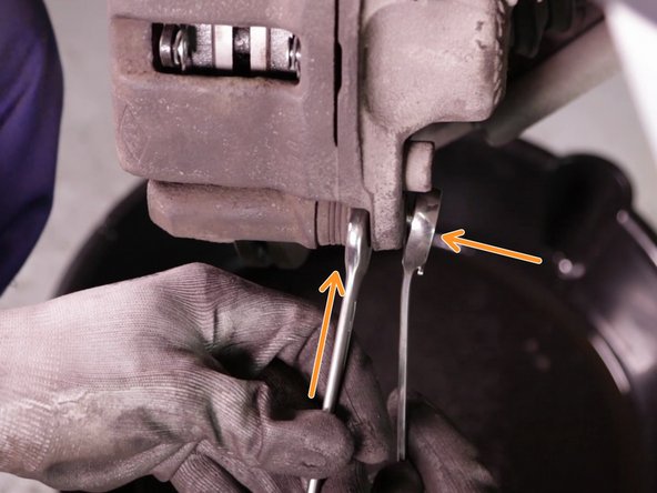 
Close the brake caliper, then insert the caliper screw. Tighten it using the ratchet with the 18 socket and the 17 flat wrench.
