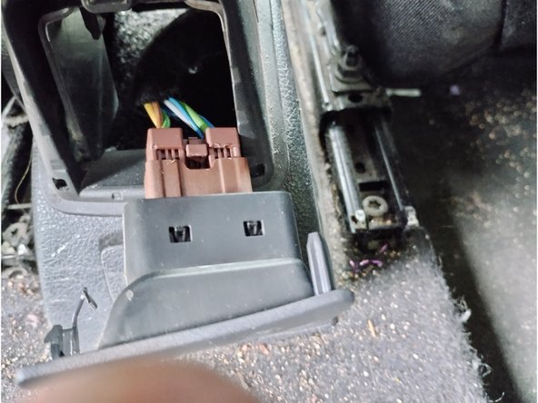 Reposer la console centrale et l'accoudoir à l'aide d'une clé Torx de 20, sans oublier de reconnecter les boutons de vitre arrière et de start and stop