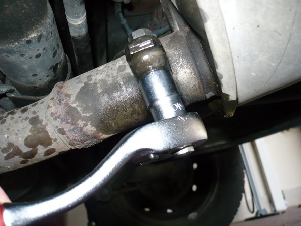 Desserrer l'écrou à l'aide d'un  cliquet+ (douille de 13 mm) et d'une  clé plate de 13 mm (l'une sur la tête de vis et l'autre sur l'écrou).