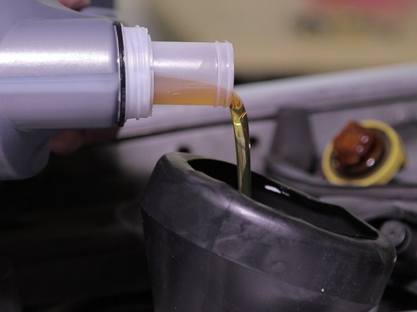 Verser environ 4l d'huile constructeur dans l'entonnoir