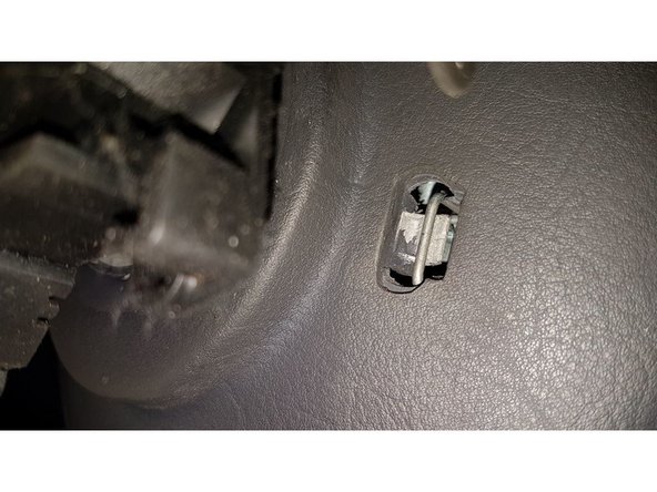 Sous le volant, appuyer sur les deux ressorts de fixation du module d'airbag.