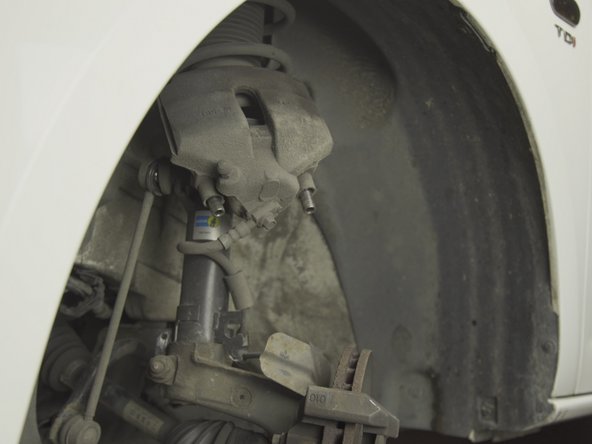 Caler l'étrier sur la jambe de force afin de ne pas faire pendre l'étrier par son flexible de frein