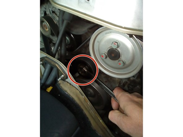 Bien mémoriser le cheminement de la courroie pour facilité le remontage. Positionner la clé de 24 mm sur le tendeur et exercer une pression vers le bas afin de détendre et libérer la courroie en commençant par la pompe DA puis le compresseur de climatisation.