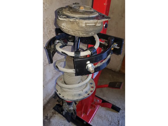 Compressez le ressort jusqu'à ce que la coupelle soit libre.