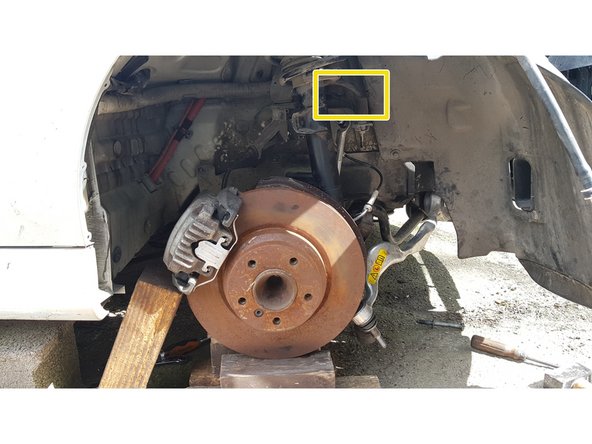 Placez un tournevis dans la fente de la fusée puis enfoncez-le suffisamment pour faciliter la glisse de l'amortisseur.