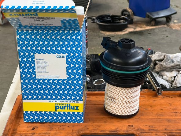 donc voici le nouveau filtre a huile que l'on va placer il a déjà un nouveau joint intégré qui est venue directement avec dans la boite on reprend le cliquet et la douille adaptée pour le visser et on fait attention a bien le serrer pour que ils soit étanche