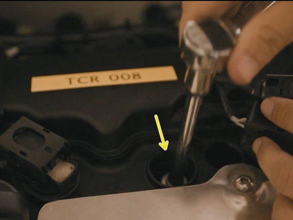 Glisser la clé à douille et desserrer la bougie à l'aide du cliquet