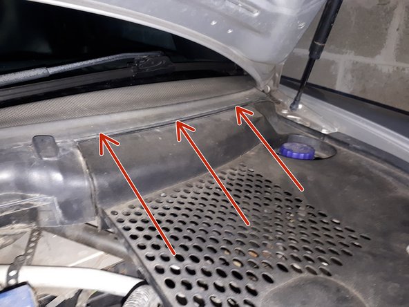 Remonter le cache de droit en le clipsant d'abord dans les emplacements montrés par les flèches rouges. Puis visser la vis Torx T25.