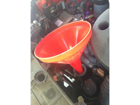 Mettre l’entonnoir pour pouvoir verser l'huile proprement