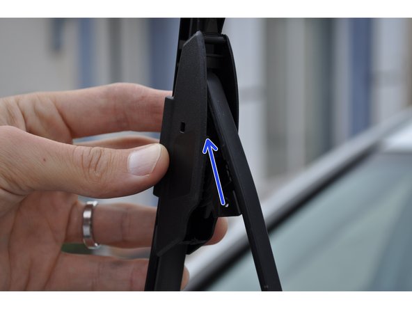 Faire passer le bras de l'essuie glace dans le balais. Inserer l'attache dans le support en forme de U. Coulisser et verrouiller le balais d'essuie glace.