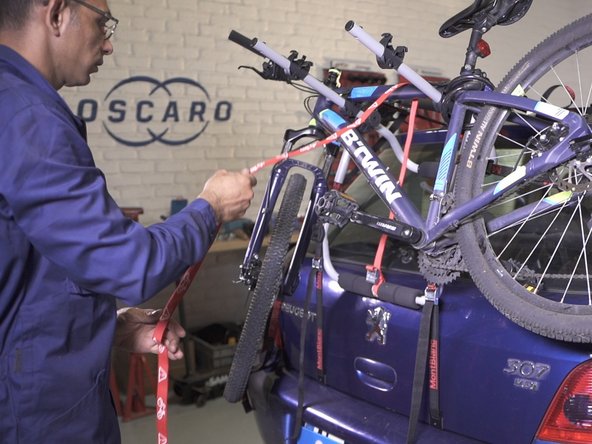 Placer la sangle rouge de manière à pouvoir maintenir le(s) vélo(s)