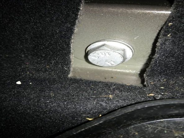 Il faut d'abor défaire le boulon supérieur de l'amortisseur. L'accès se fait par l'intérieur du véhicule. Il faut soulever à moitié le septième siège arrière, puis soulever la languette pour accéder au boulon ( voir photos ci-jointes).