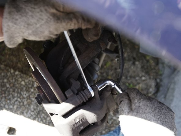 Retirez les deux vis de l'étrier à l'aide d'une clé plate de 13 et d'une clé à pipe de 13