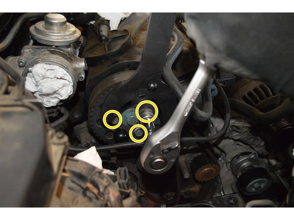 La poulie d'arbre à cames se trouve en position médiane au niveau des trous oblongs avec les écrous légèrement desserrés