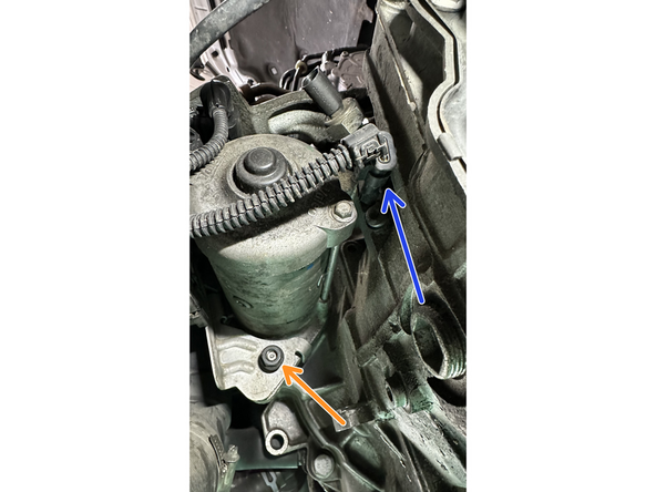 Dévisser l'écrou sur le goujon supérieur du démarreur et retirer le câble de masse noir. Le coincer vers l'AV de la voiture.