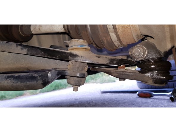 Avec une douille et une clé mixte de 18mm, retirez les 2 écrous ainsi que la vis côté intérieur puis désaccouplez la rotule du triangle.