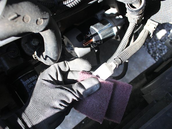 Nettoyer la portée du démarreur sur la cloche de boîte de vitesses à l'aide d'une brosse, d'un chiffon et de dégraissant.   En cas d’oxydation des cosses vous pouvez les poncer légèrement avec une éponge abrasive puis y appliquer de la graisse au cuivre les protégeant ainsi de la corrosion. 