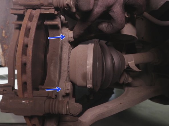 A l'aide du cliquet et de la douille de 18 desserrer et retirer les 2 vis du support de l’étrier