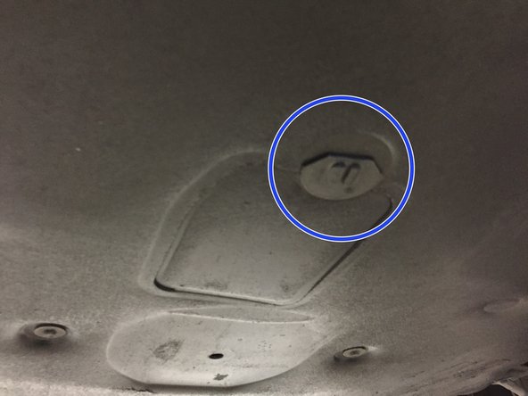 Sous le véhicule ce trouve le cache inférieur. Faire un demi tour sur l’écrou de maintien