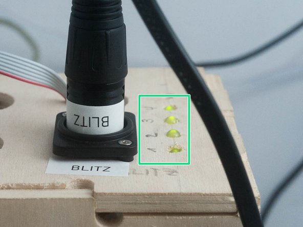 Alle 4 Statuslampen an der hellen Holzbox müssen grün leuchten.