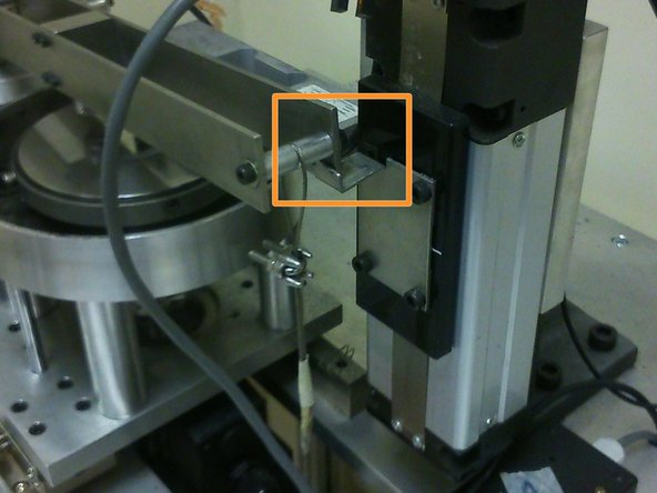 Place the end of the cantilever beam on the edge of the actuator's arm.