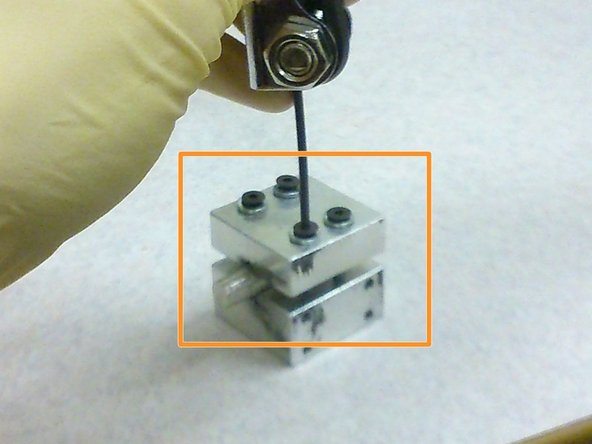 The two screws have to be tightened concurrently so that the two halves of the sample holder would be parallel to one another.