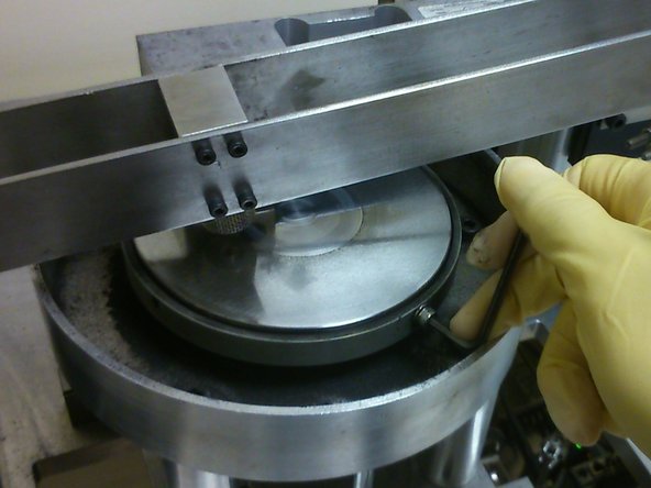 Using an allen key, secure the disk onto the disk holder by hand-tightening at least two M4 screws at opposite sides of the disk.