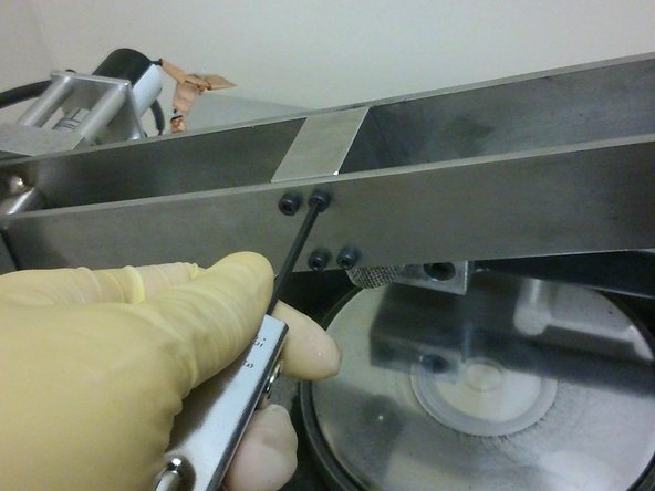 Using an allen key, secure the sample holder onto the cantilever beam using four M3 screws on the side of the cantilever beam facing the user.