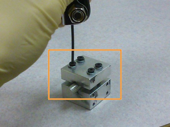 Using an allen key, tighten the two screws closer to the bottom of the sample holder.