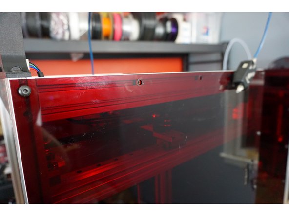 On the right side of the printer, locate the second and third bolts across the top edge from the front that holds the acrylic to the aluminum.