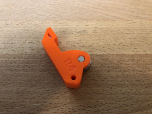 Insert bearing ping into side of extruder idler.