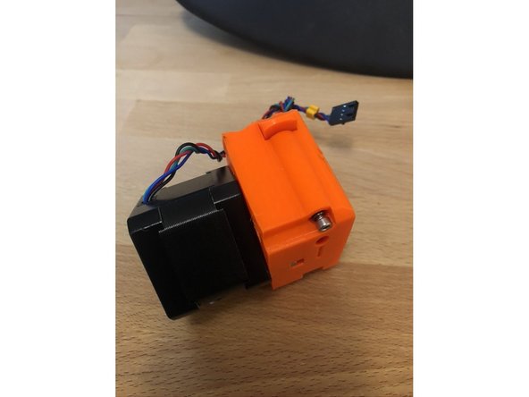 Insert the M3 x 40mm screw and spring into the bottom side of the extruder and tighten.