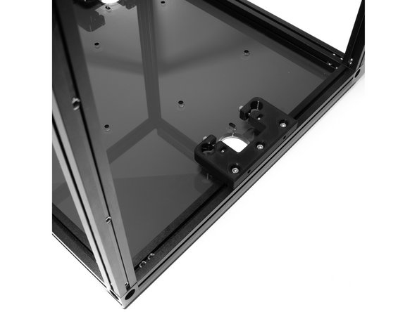 On the left side of the frame, attach (1) Z rod holder to the bottom right extrusion using (3) M3 x 10 socket head screws.  Leave 2 M3 nuts free towards the back extrusion as pictured.