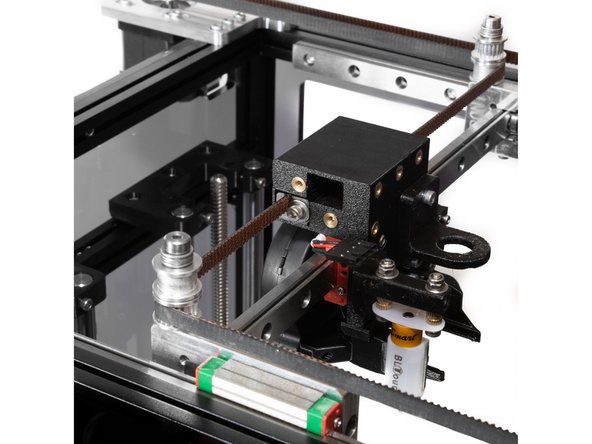 From there the belt should follow along the back of the printer, with the toothed side wrapping around the lower toothed idler on the X carriage.
