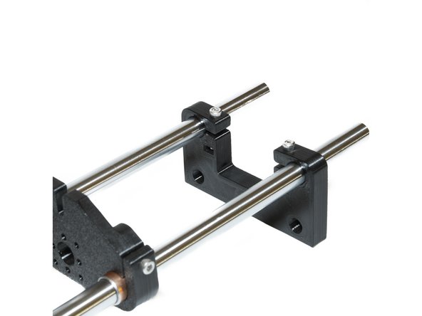 Using (2) M3 nuts and (2) M3 x 20 socket head screws, attach a Z rod holder to the bottom of the smooth rods, leaving about 15mm of smooth rod at the bottom.