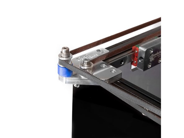 From the X carriage the belt follows along the front of the printer to the toothed idler at the top of the tall stack on the front idler mount.