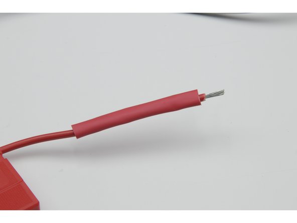 Cut and slide a 60mm length of heat shrink over the red fuse wire.