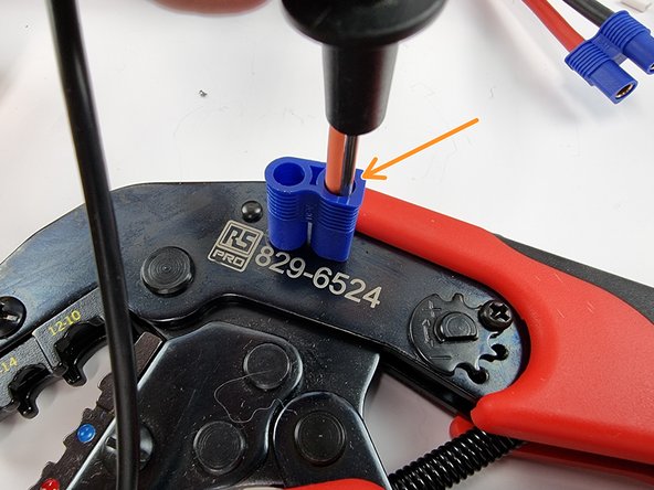 Insert the red wire into the hole with the flat side.