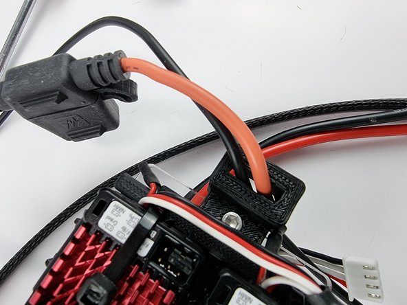 Before we install the pin onto the end of the red wire from the fuse holder feed the wire through the 3D Printed EC3 holder at the end of the support plate.