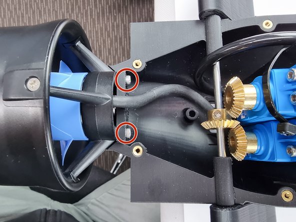 Insert the 2 bolts that were removed from the shroud into the 2 holes in the bottom aft cap to secure the thruster in place