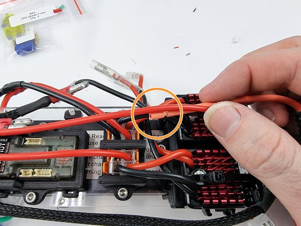 Grab the wire from the power switch that was just soldered. We will join this with one of the wires from the fuse holder.