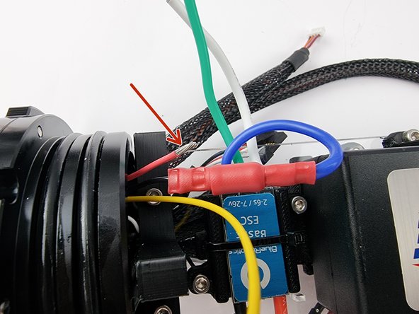 Trim the red wire and strip the insulation from the end of the wire to prepare it for the bullet connector