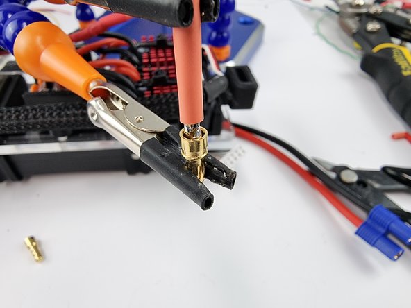 Secure the pin and the wire together so that they can be soldered together.